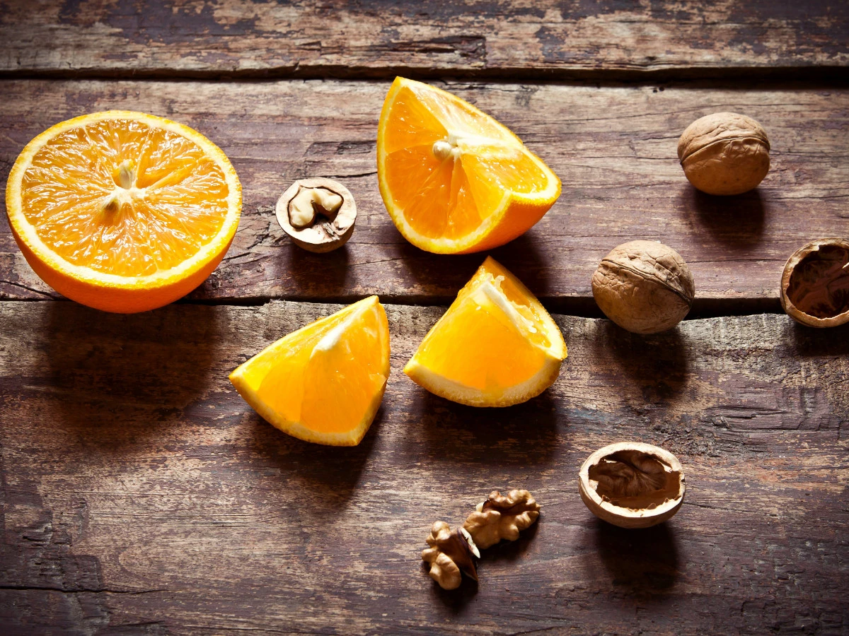  Orangen und Nüsse auf Holz 