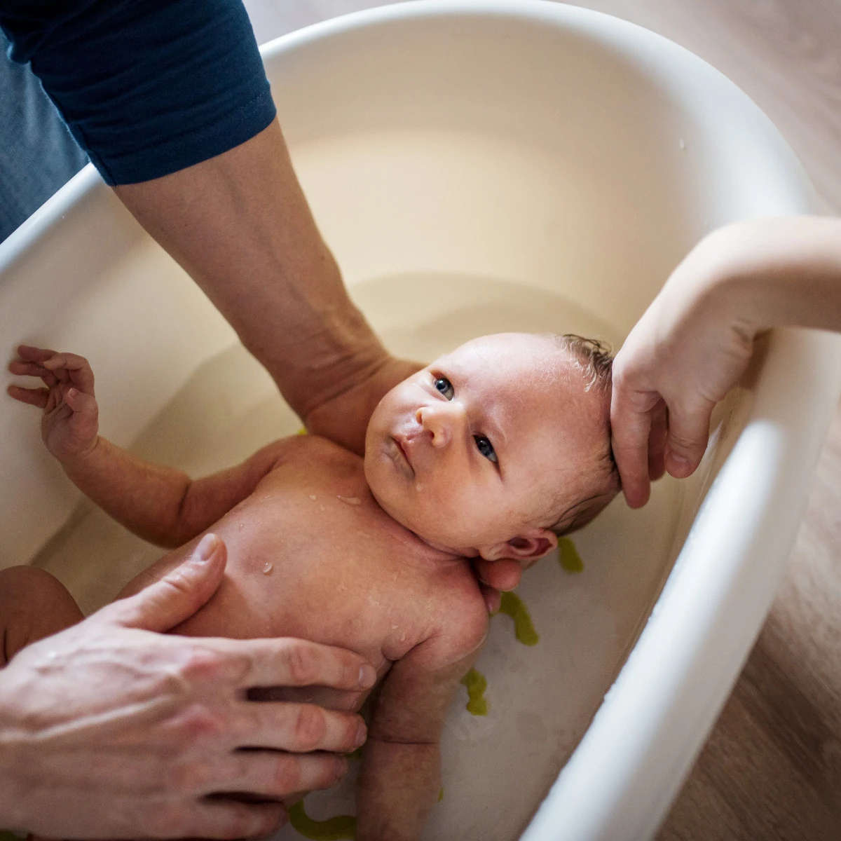  Baby wird in einer kleinen Badewanne gebadet 