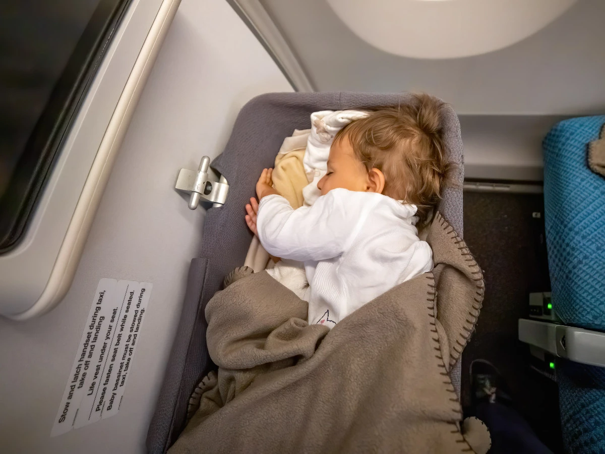  Kleinkind schläft sicher und bequem im Babybusse auf einem langen Flug 