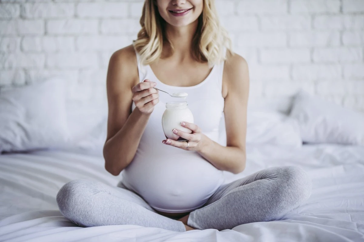  Schwangere Frau isst Joghurt 