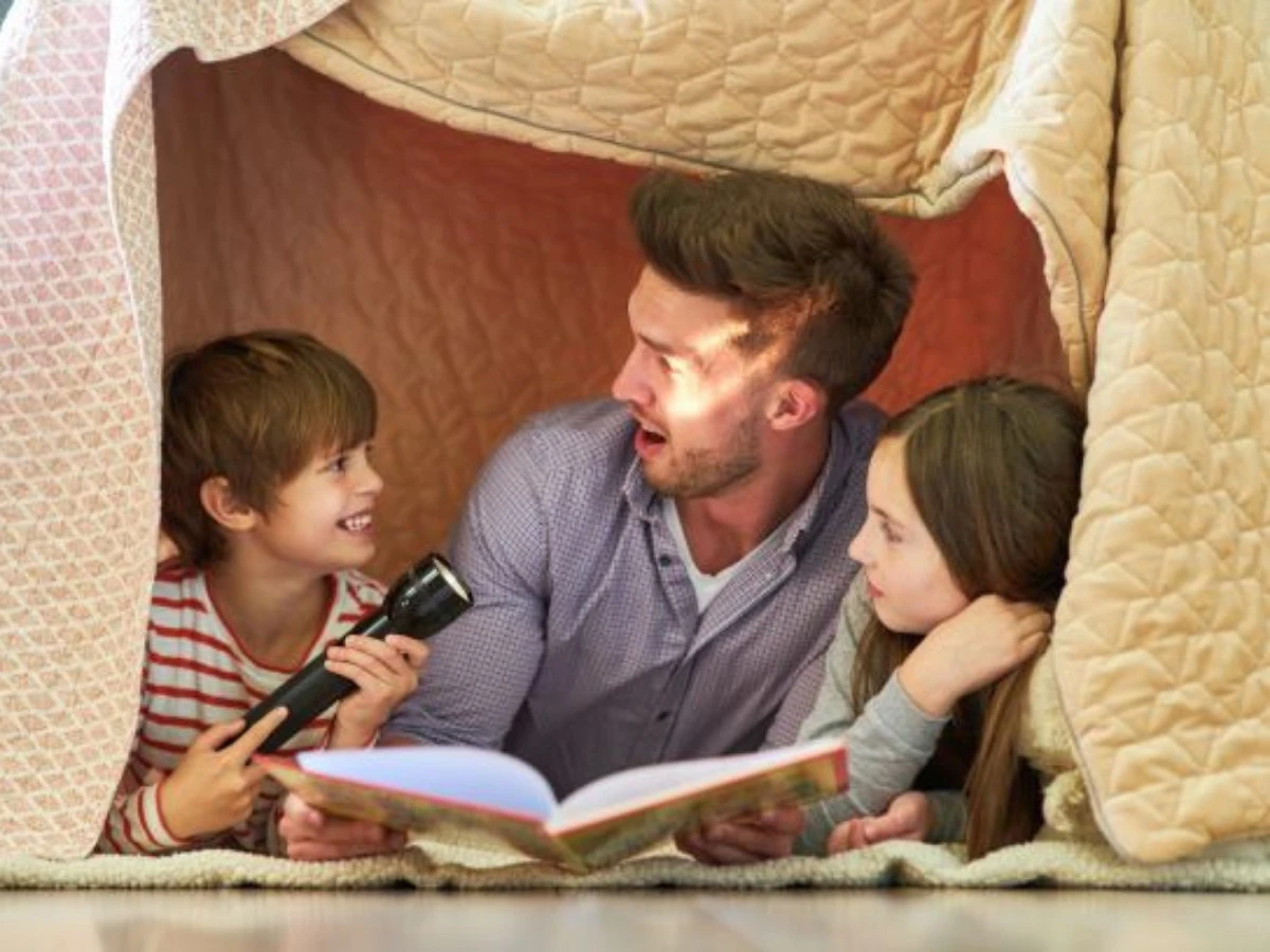  Vater mit Kindern beim Bücher vorlesen 