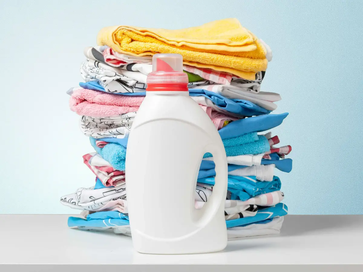  Waschmittel mit bunten Handtüchern im Hintergrund 